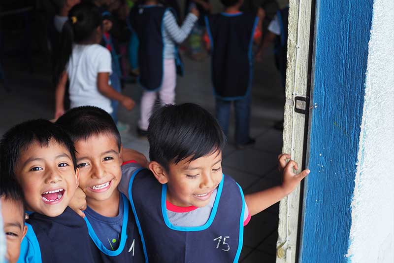Children smile for the camera in the teaching project in Guatemala