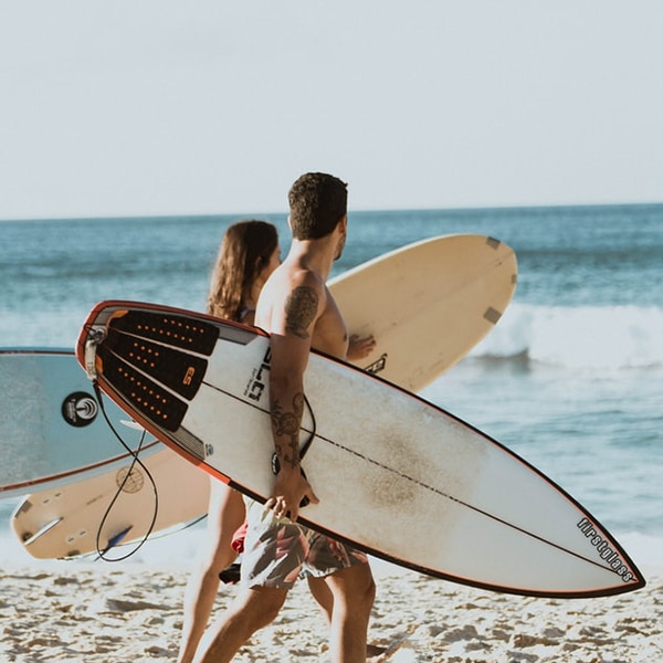 Zwei Menschen mit Surfbrettern
